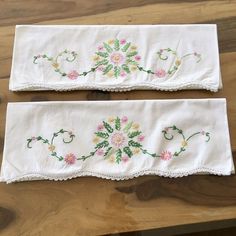 two embroidered table runners with flowers on them