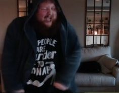 a man in a hoodie is playing video games on the television screen with his mouth open