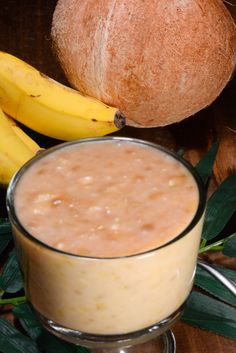 a glass filled with liquid next to some bananas