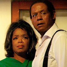 a man standing next to a woman wearing a green shirt and black suspender tie