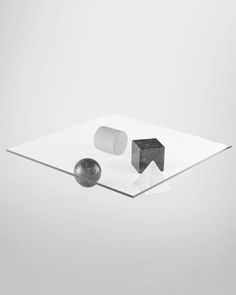 an object is sitting on top of a glass table with two balls in front of it