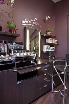 a salon with purple walls and wooden flooring, counter space for hair care products