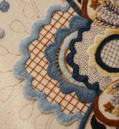 a close up view of an intricately designed piece of cloth with blue and brown accents