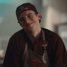 a smiling man wearing an apron and hat with the words friends written on it in front of him