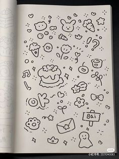 an open book with doodles and drawings on the pages, including numbers and symbols