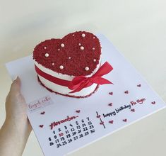 a heart shaped cake on top of a calendar