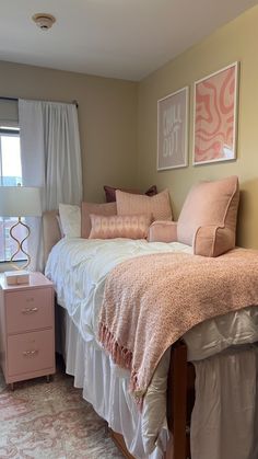 a bedroom with pink and white decor on the walls, bed in front of window