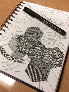 a spiral notebook with black and white designs on it