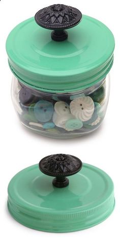 two glass jars with buttons in them on a white background, one is green and the other is black