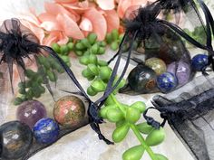 three organ bags filled with marbles on top of a white cloth covered table next to flowers