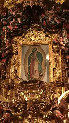 an ornate gold frame with cherubs and angels on it in front of a painting