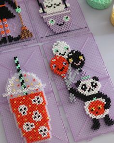 four cross stitch coasters are arranged on a table with beads and sprinkles