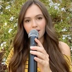 a woman with long hair holding a microphone