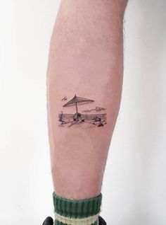 a man's leg with an umbrella tattoo on it