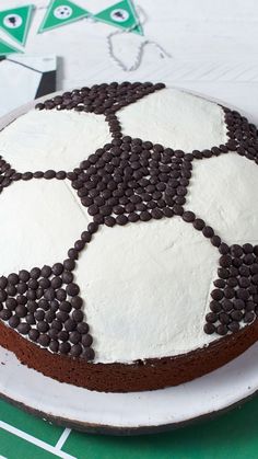 a cake decorated with chocolate chips and white frosting on a green tablecloth,