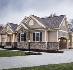 a house with two garages in the front and one on the other side that is made out of stone