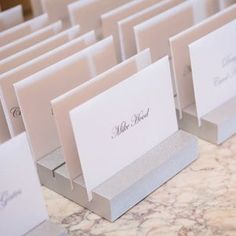 there are many cards on the table with name tags attached to each card and envelope