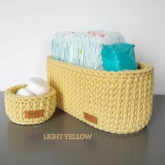 a knitted yellow basket with two rolls of toilet paper in it and the words light yellow written below