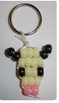 a keychain made to look like a sheep with black, white and pink beads