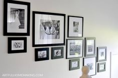 a white wall with many black and white pictures on it