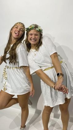 two girls in white dresses posing for the camera