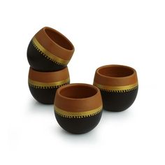 three brown and black bowls sitting next to each other on a white surface with gold trimmings