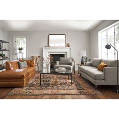 a living room with two couches and a rug on the floor in front of a fireplace