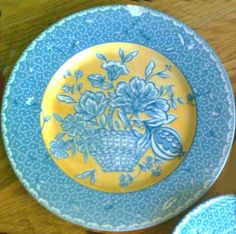 a yellow and blue plate sitting on top of a wooden table