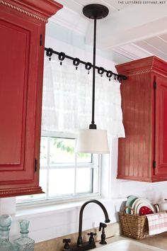 the kitchen is decorated in red and white with lots of black hardware on the cabinets