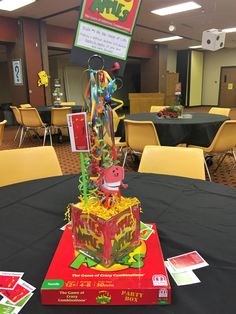 a table topped with a cake covered in cartoon characters on top of a black table cloth