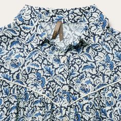 Crafted from soft, lightweight 100% rayon, this loose-fit women's blouse features a richly colored allover Indigo Tapestry print. It has a loose ruffled lower bodice with gathered ¾ sleeves that are finished with two-button cuffs and piping. The classic pan collar has a full front button down closure, while the front and back Western style yokes feature piping for added style. Perfect for both day and evening occasions, it has an easy elegance and eye-catching style. Gathered ¾ Sleeves Into 2 Bu Flowy Cotton Blouse With Print, Flowy Cotton Printed Blouse, Summer Long Sleeve Blouse With All Over Print, Bohemian Blue Printed Shirt, All Over Print Long Sleeve Blouse For Summer, Summer Long Sleeve Printed Blouse, Long Sleeve Blouse With All Over Print For Summer, Patterned Relaxed Fit Blouse For Vacation, Blue Relaxed Fit Tunic Blouse