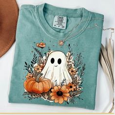 Ghost Shirt, Comfort Colors, Fall Ghost Shirt, Floral Ghost Shirt, Boho Ghost tshirt, Halloween Ghost, Funny Ghost, Fall Shirt, Autumn Shirt ☀️Popular Comfort Color 1717 tshirts ☀️Preshrunk, soft-washed, garment-dyed fabric ☀️Sizes: S-4X size up for an oversized tshirt fit. great for small business owners bridal parties  birthday shirts spring outfit nature lovers Christmas gifts Holiday Parties Care instructions: Machine wash cold inside out. Dry on low.  Shipping: Items will ship within 1-5 bu Green Cartoon Print Top For Fall, Green Cartoon Print Tops For Fall, Fall Cotton Tops With Character Print, Cotton Tops With Character Print For Fall, Fall Cotton Shirt With Cartoon Print, Casual Green Halloween Top, Long Sleeve Shirt With Halloween Character Print, Blue Pre-shrunk Tops For Halloween, Fall Cotton T-shirt With Character Print