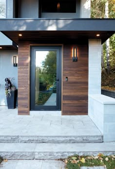 the front door of a modern home with wood paneling