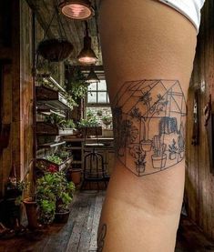 a woman's leg with a tattoo on it that has plants and potted plants