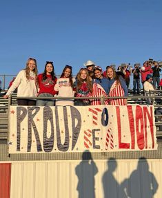 a group of young women standing next to each other in front of a banner that says proud to the lion