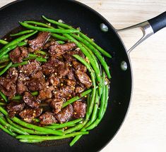 green beans and meat in a skillet on a table