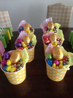 three buckets filled with candy sitting on top of a table