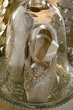 there is a glass bellow with white shoes on it and silver sequins