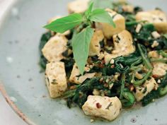 a plate with tofu and greens on it