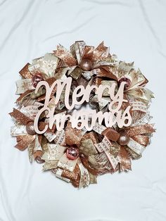 a christmas wreath with the words merry grandmas written in white and gold on it