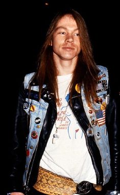 a man with long hair wearing a jean jacket