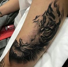 a black and white tiger tattoo on the arm