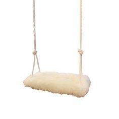 a white sheepskin hammock hanging from a rope