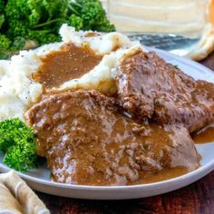 some meat and gravy on a plate with broccoli