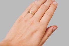 a woman's hand with a gold ring on it