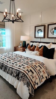 a bedroom with a bed, chandelier and pictures on the wall