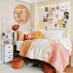 a bedroom decorated in orange and white with pictures on the wall above the bed, along with lights