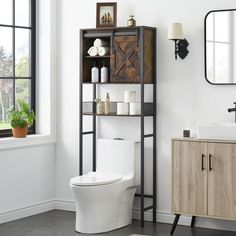 a white toilet sitting next to a wooden cabinet in a bathroom near a window with a potted plant