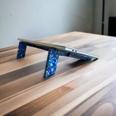 a wooden table topped with a laptop computer on it's side and an upside down lap top