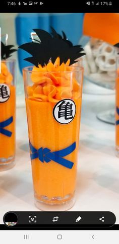 an orange dessert in a tall glass with blue ribbon around the edge and dragon decorations on top